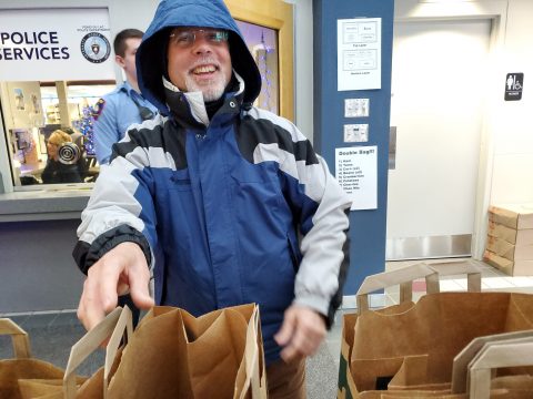 Pastor Ancheta packing groceries for the needy at the Fond du Lac Police Department. 